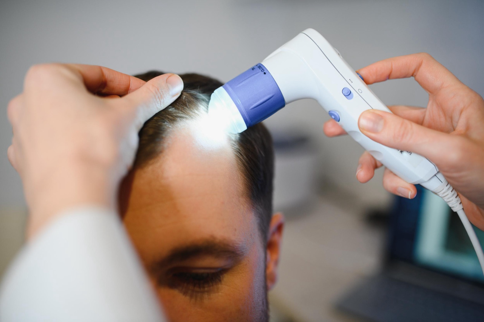 Clinician performing a scalp assessment at CADMEN Clinic